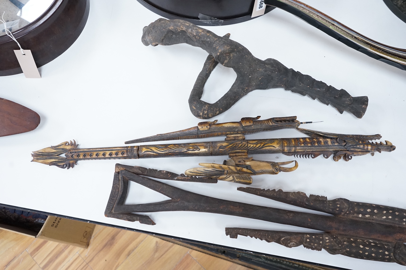 Two Papua New Guinea Sepik River carvings and a carved bone artefact, largest 92cm in length